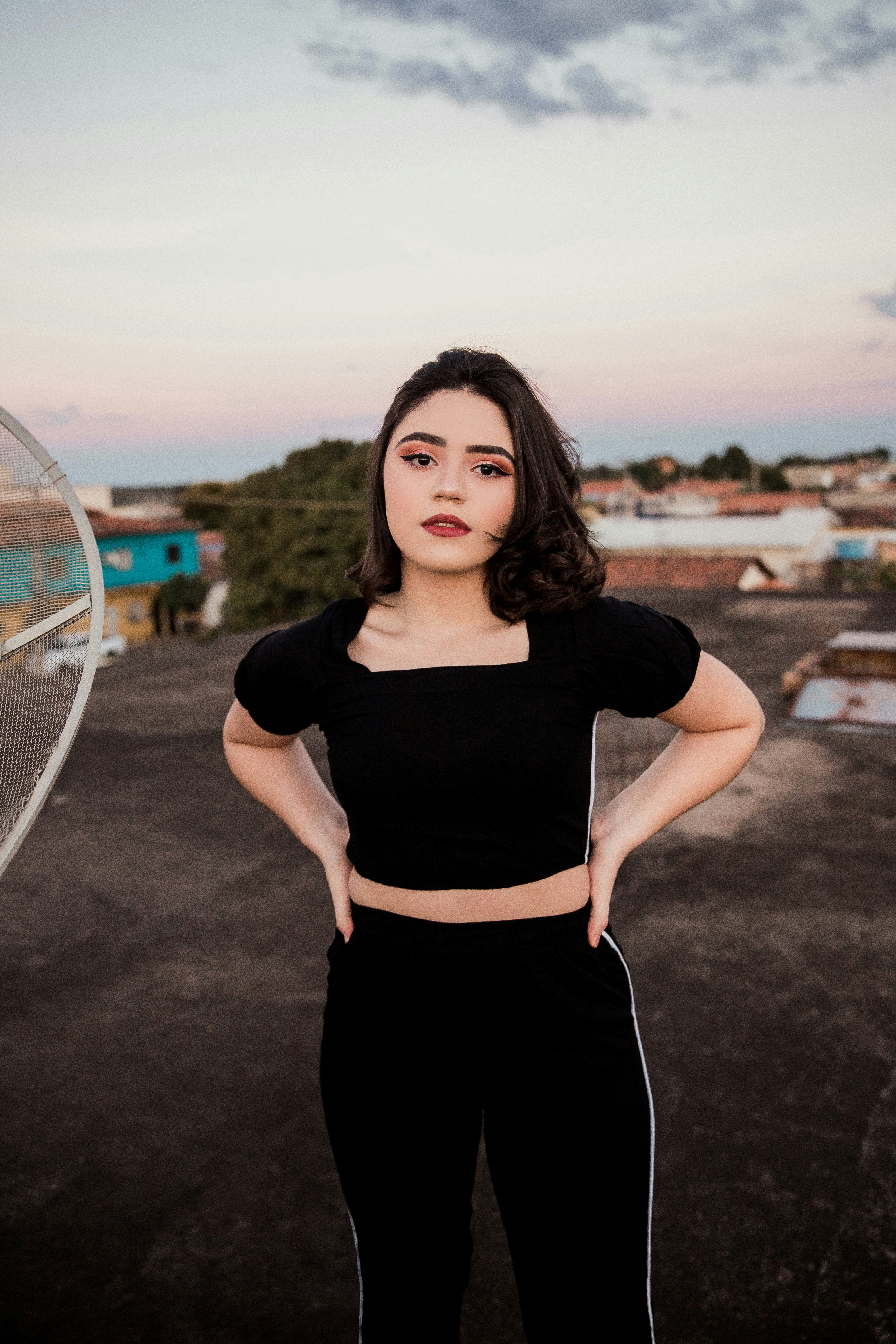 woman in black crew neck t-shirt and black skirt standing beside white and blue tennis